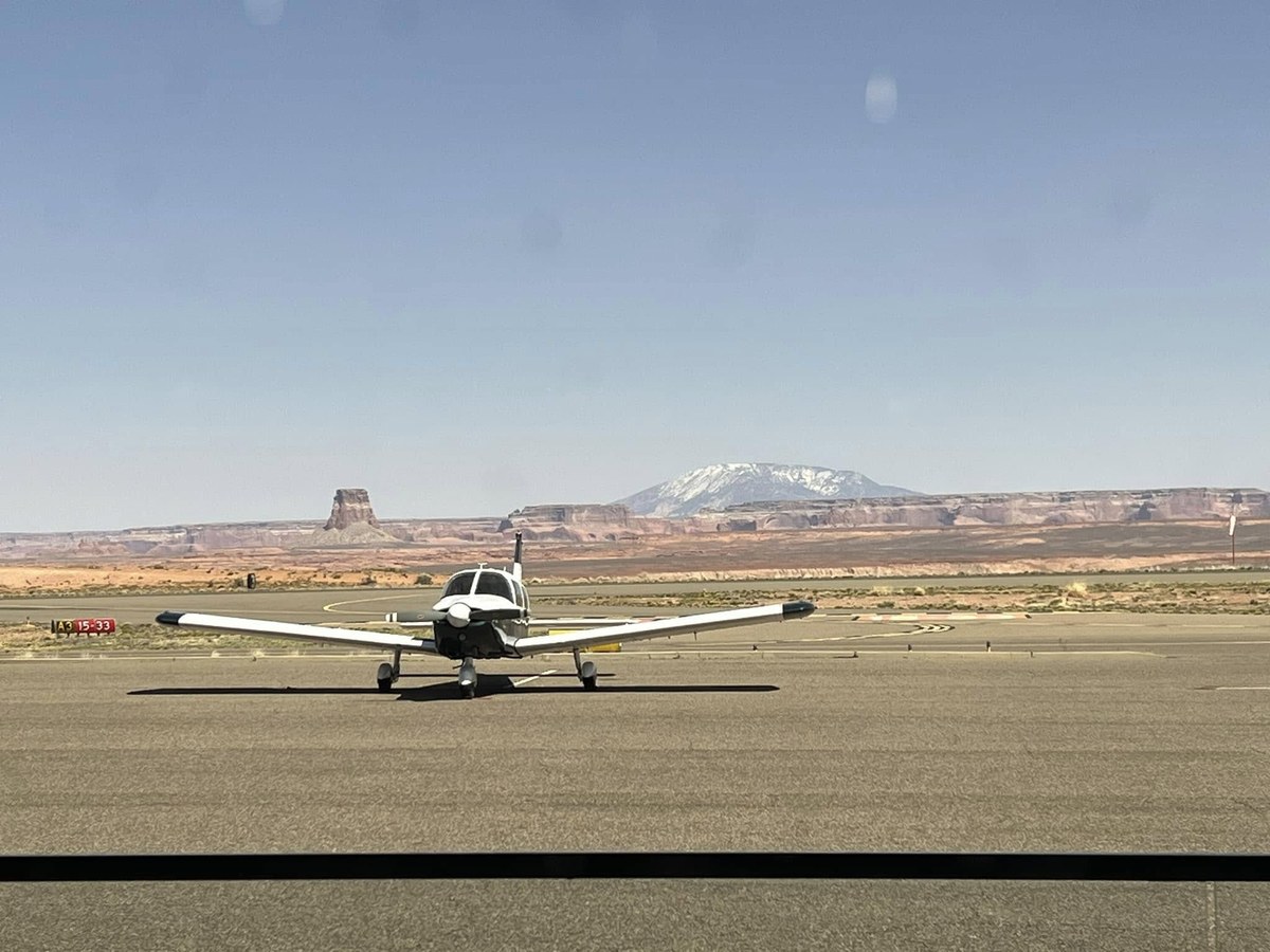 Cessna parked at a remote airstrip with desert landscape behind