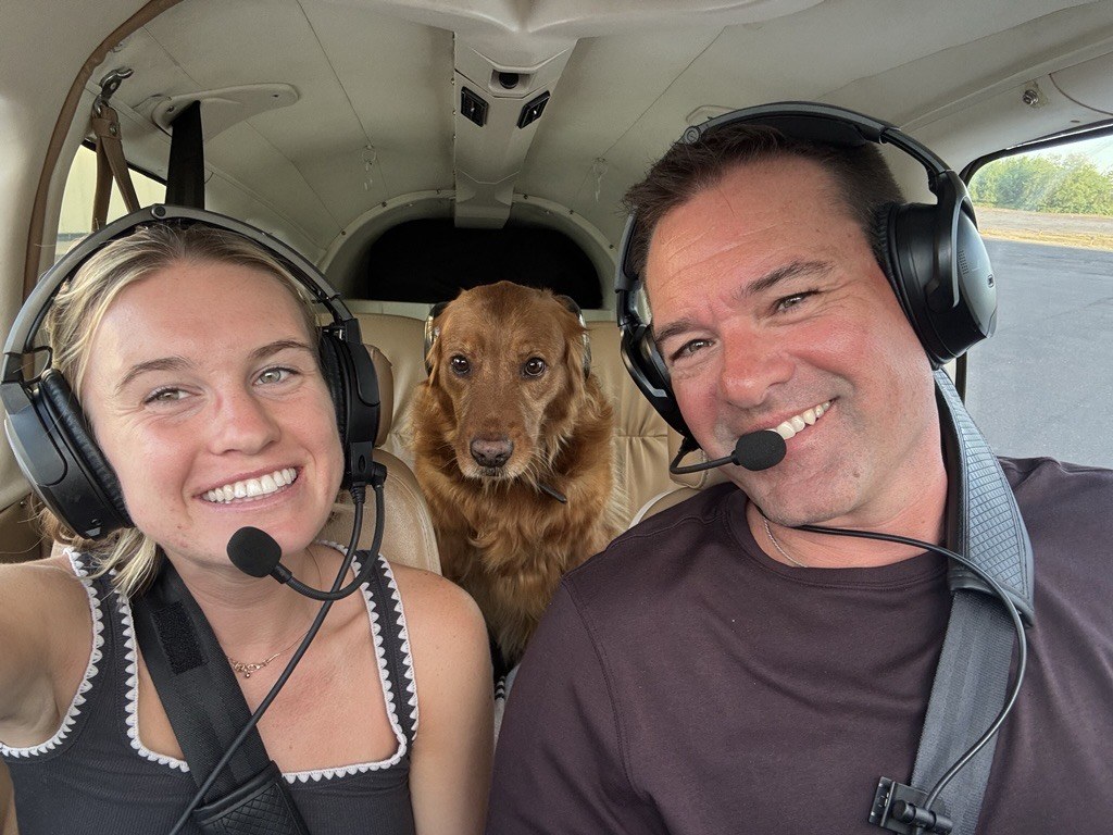 Gary Burmaster, CEO of All Inclusive Realty Group, in the Piper cockpit with Lola the golden retriever